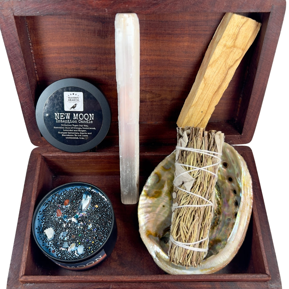 Présentation du Coffret Rituel de Nouvelle Lune, composé d'une bougie énergétique, d'un bâton de sélénite, de palo santo, de sauge blanche et d'une coquille d'ormeau (abalone)